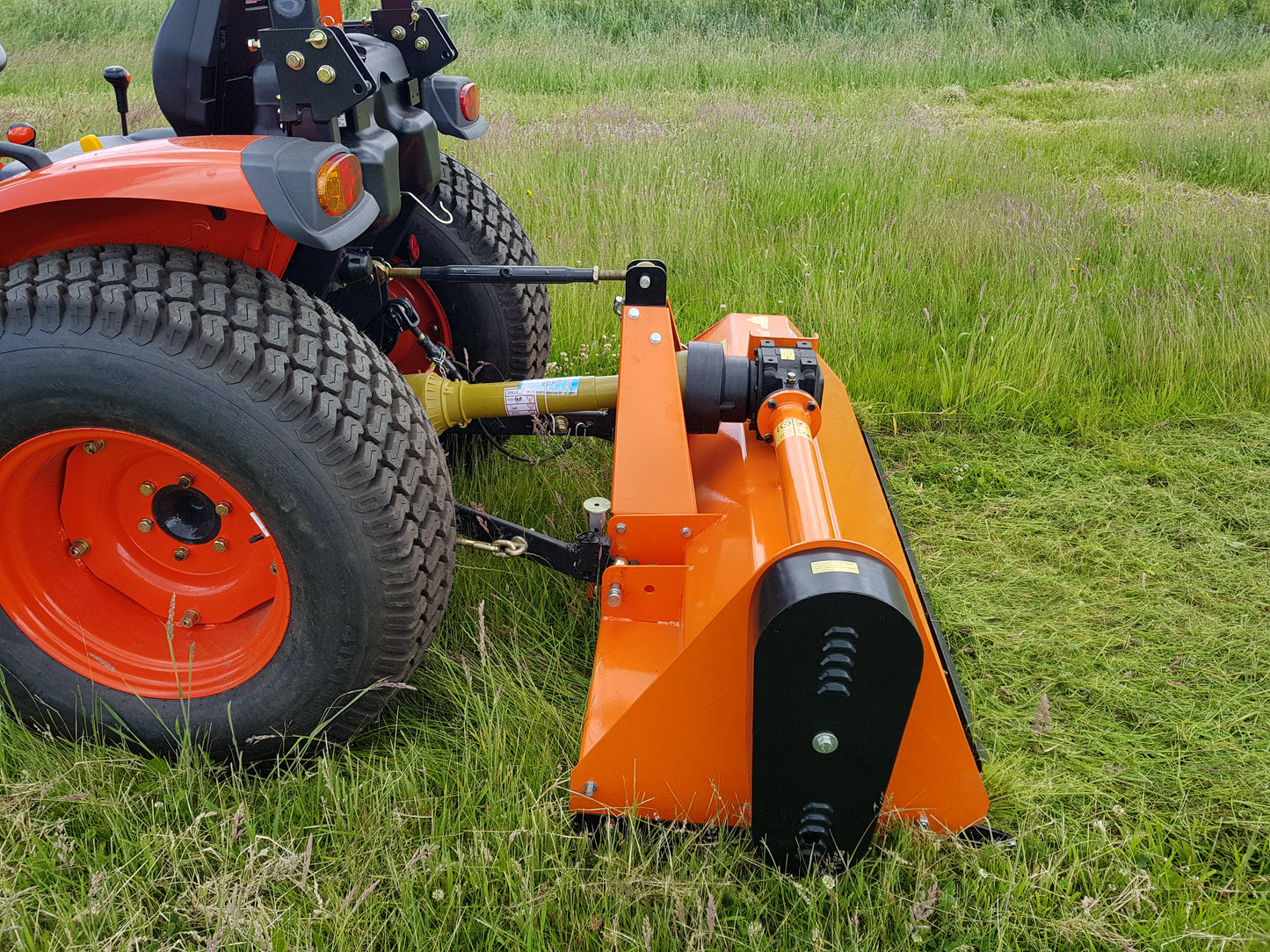 FarmMaster tractor flail attachment on a tractor in a grassy field