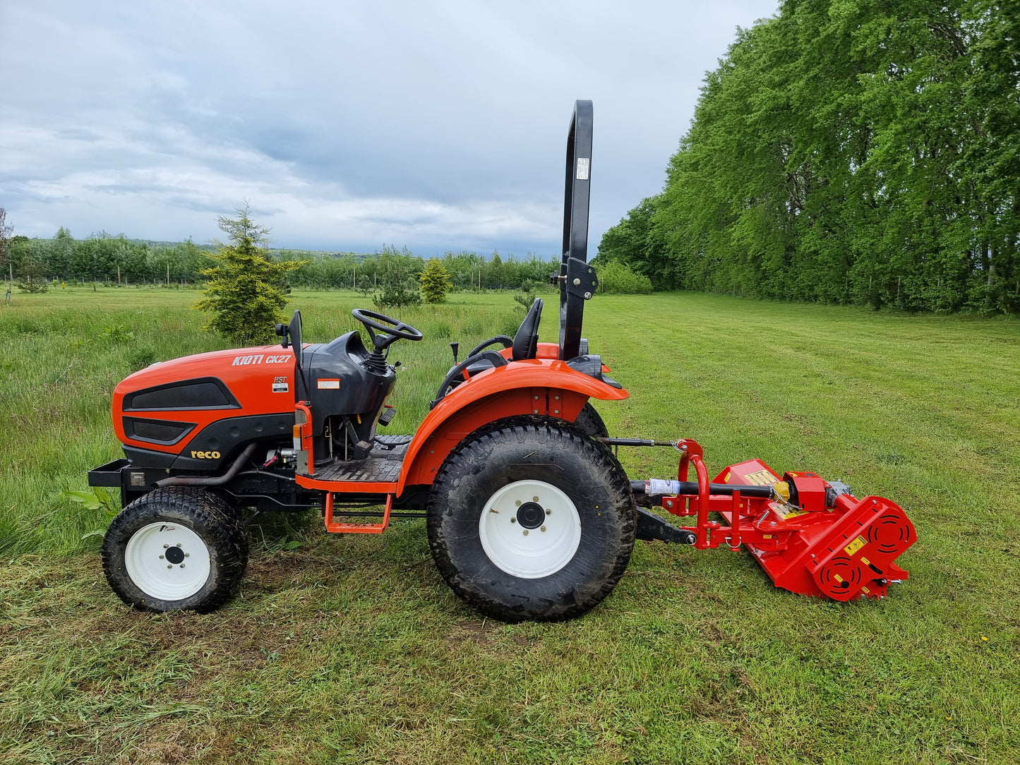FarmMaster Pro Side-Shift flail mower attachment on a grassy field with trees in the background