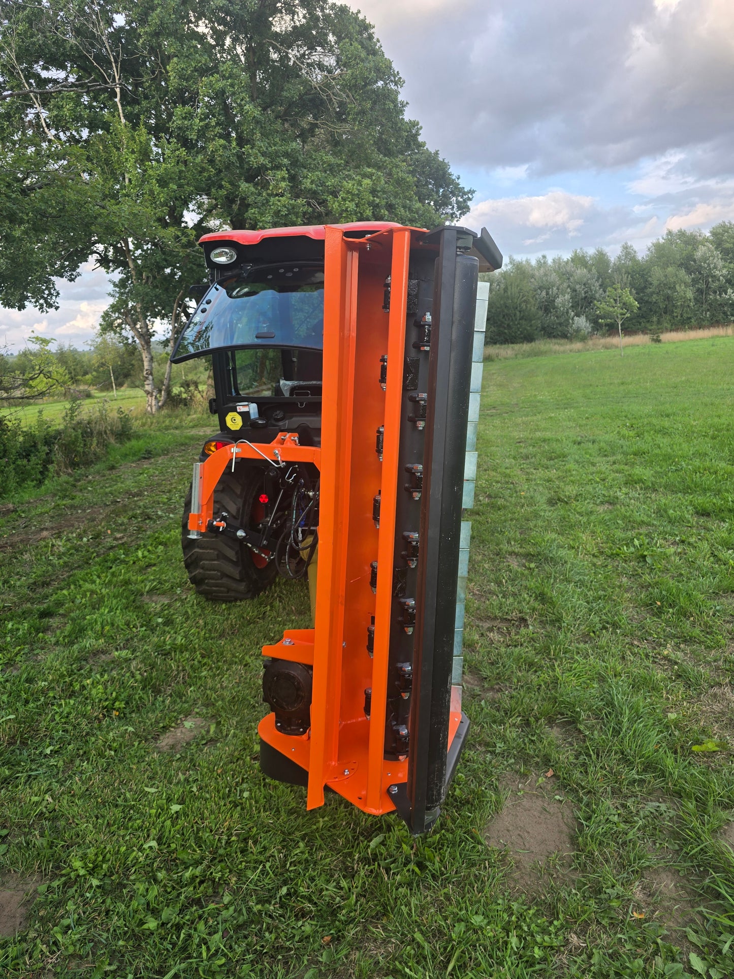 FarmMaster Verge Flail Mower on grass with trees in the background