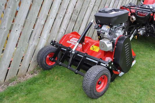 Logic ATV flail mower on grass with wooden fence in the background