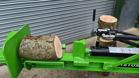 Green FarmMaster Goliath tractor log splitter with logs.