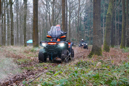 Two CFMOTO ATVs navigating a trail through a forest