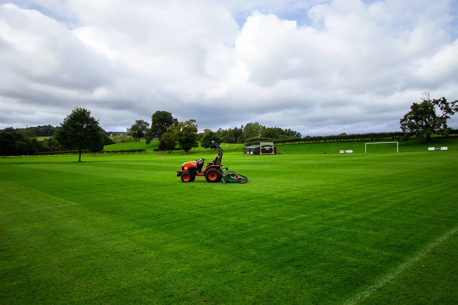 Person using a tractor to mow a large green field with a Wessex finishing mower
