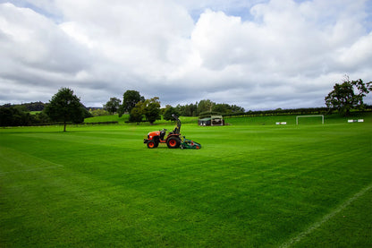 Person using a tractor to mow a large green field with a Wessex finishing mower