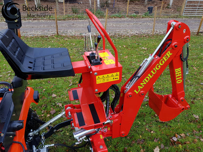 FarmMaster tractor backhoe on a grassy area.