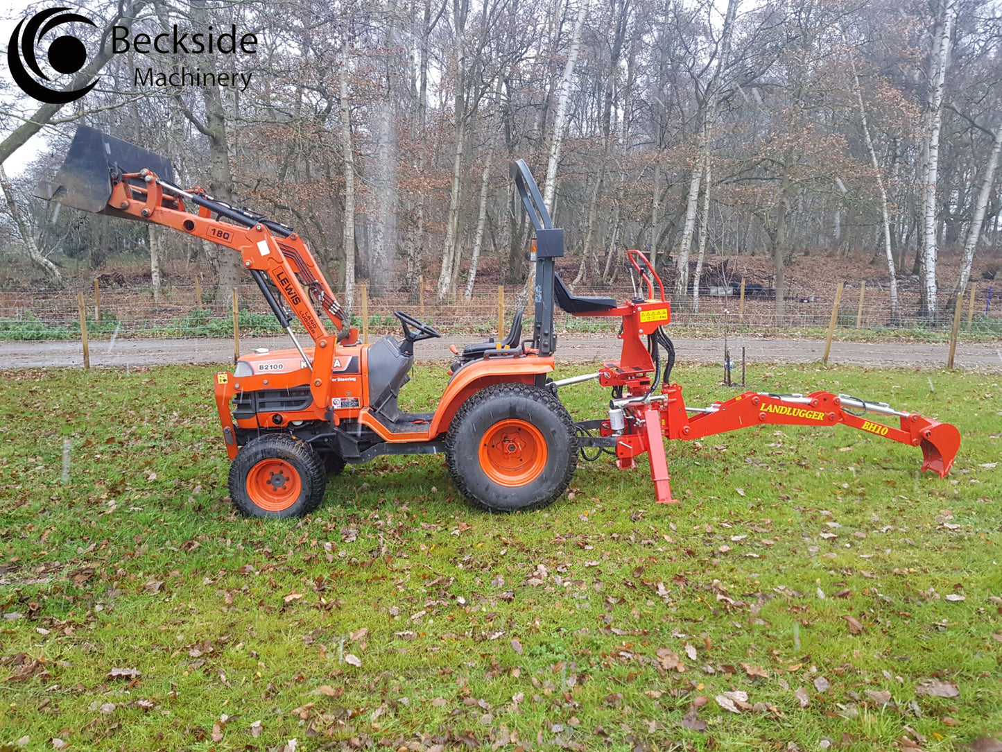 Orange tractor with a FarmMaster LandLugger tractor backhoe