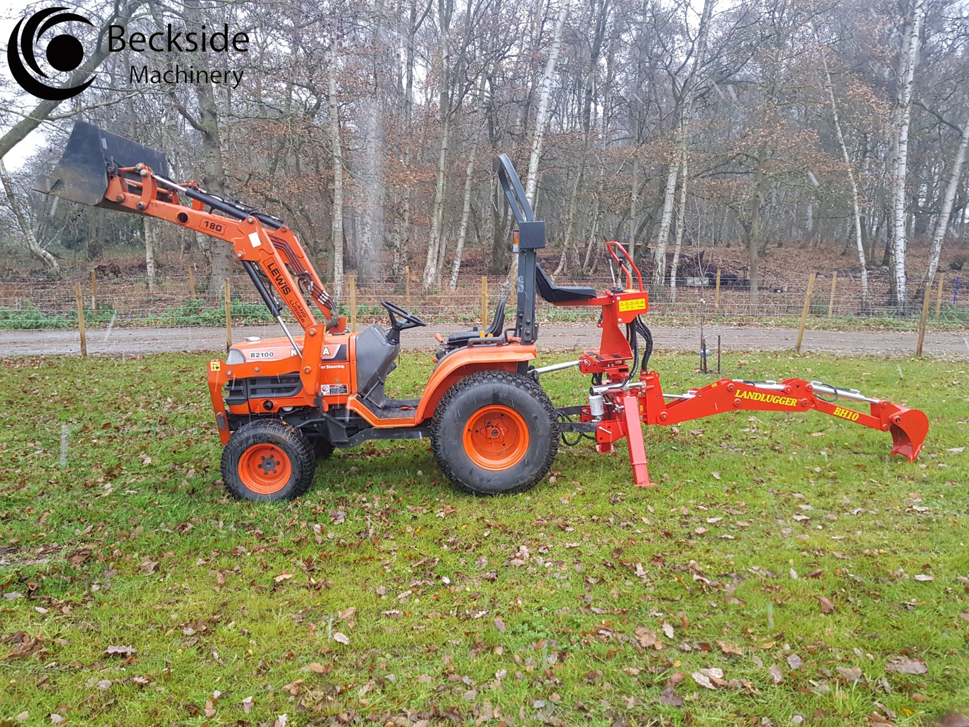 Orange tractor with a FarmMaster LandLugger tractor backhoe