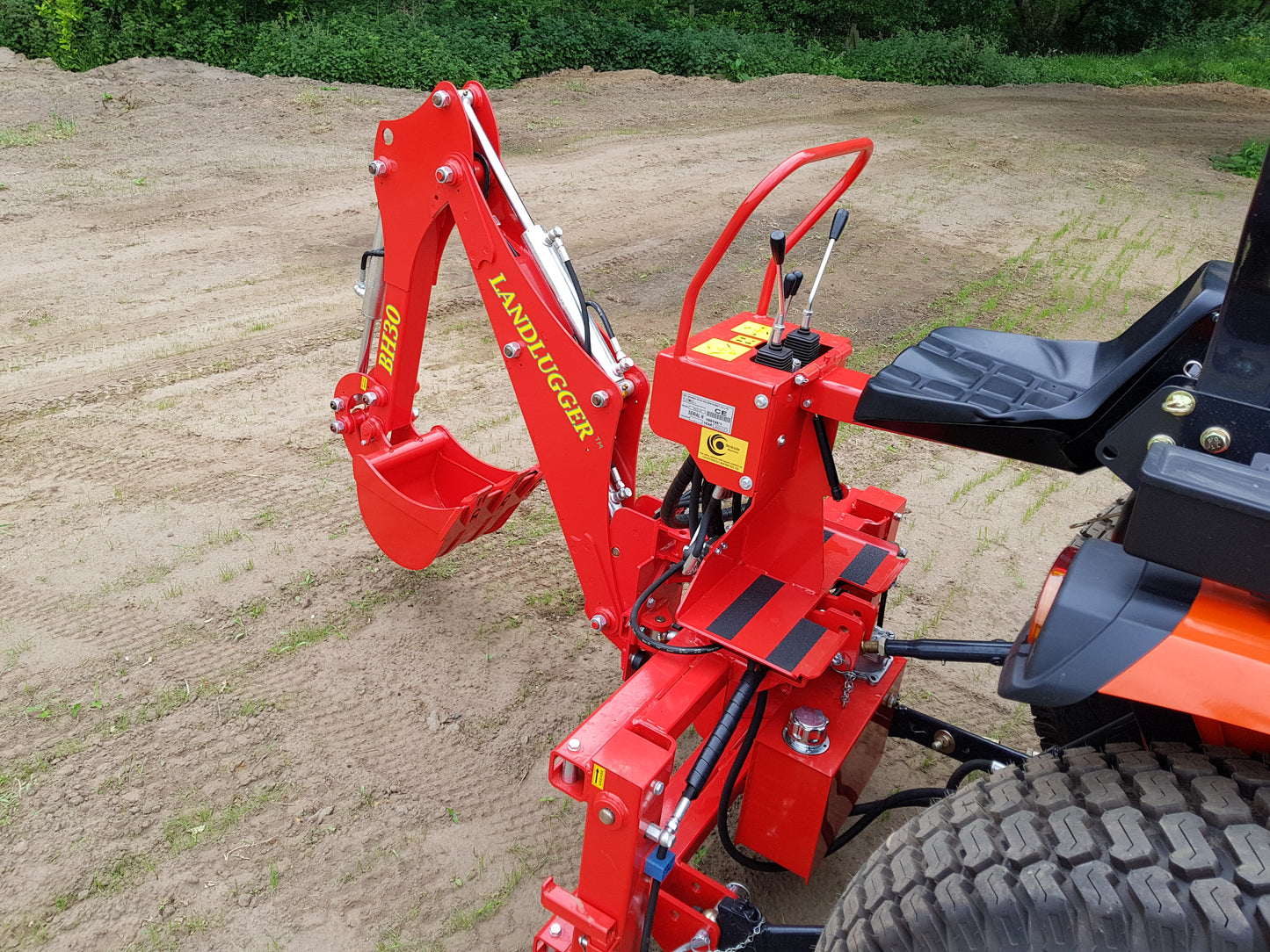 FarmMaster LandLugger tractor backhoe attached to a vehicle on a field