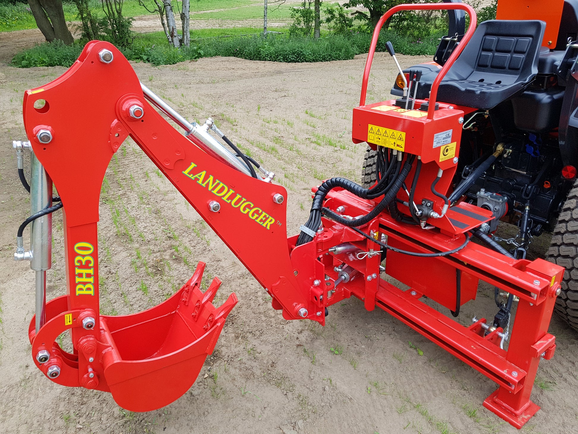 FarmMaster LandLugger tractor backhoe on a tractor in an outdoor setting.