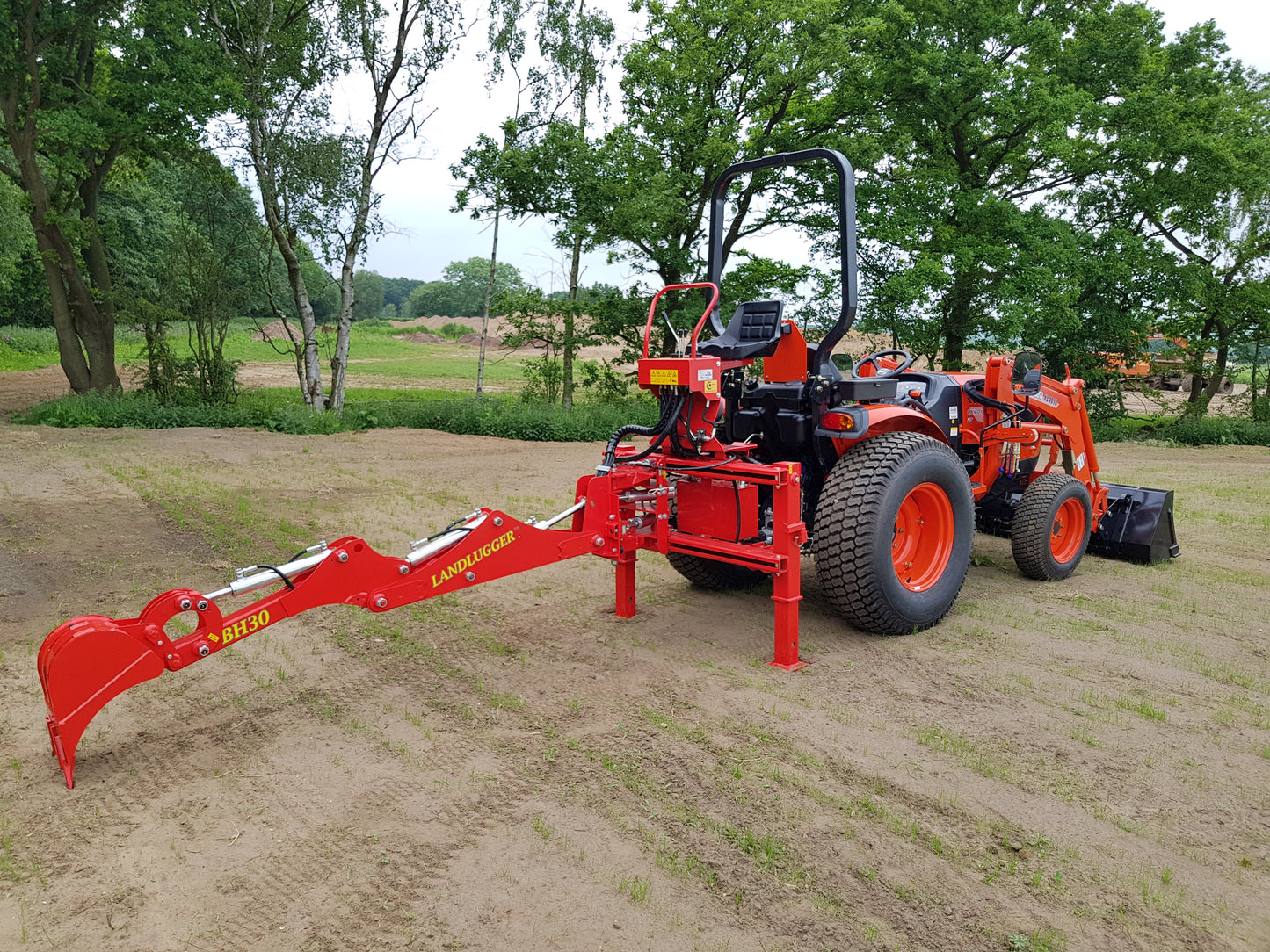 FarmMaster LandLugger tractor backhoe with trees in the background