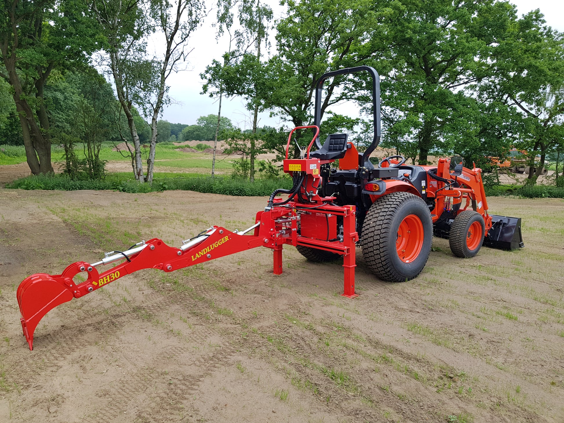 FarmMaster LandLugger tractor backhoe with trees in the background