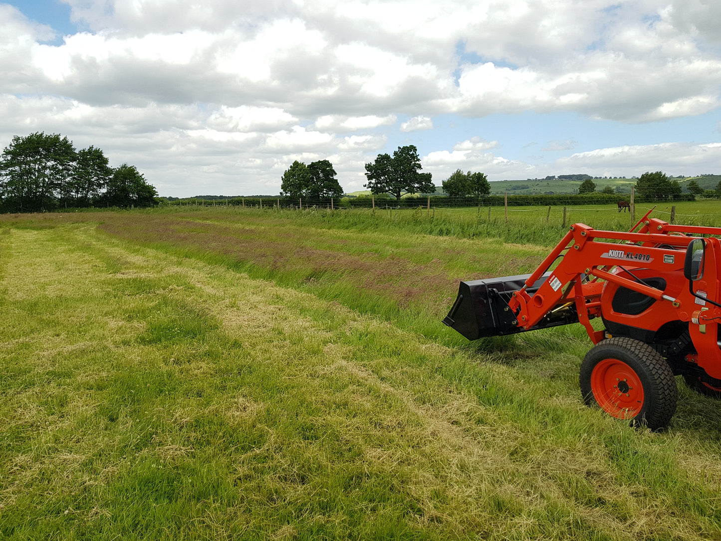 Kioti tractor in a field with a clear sky