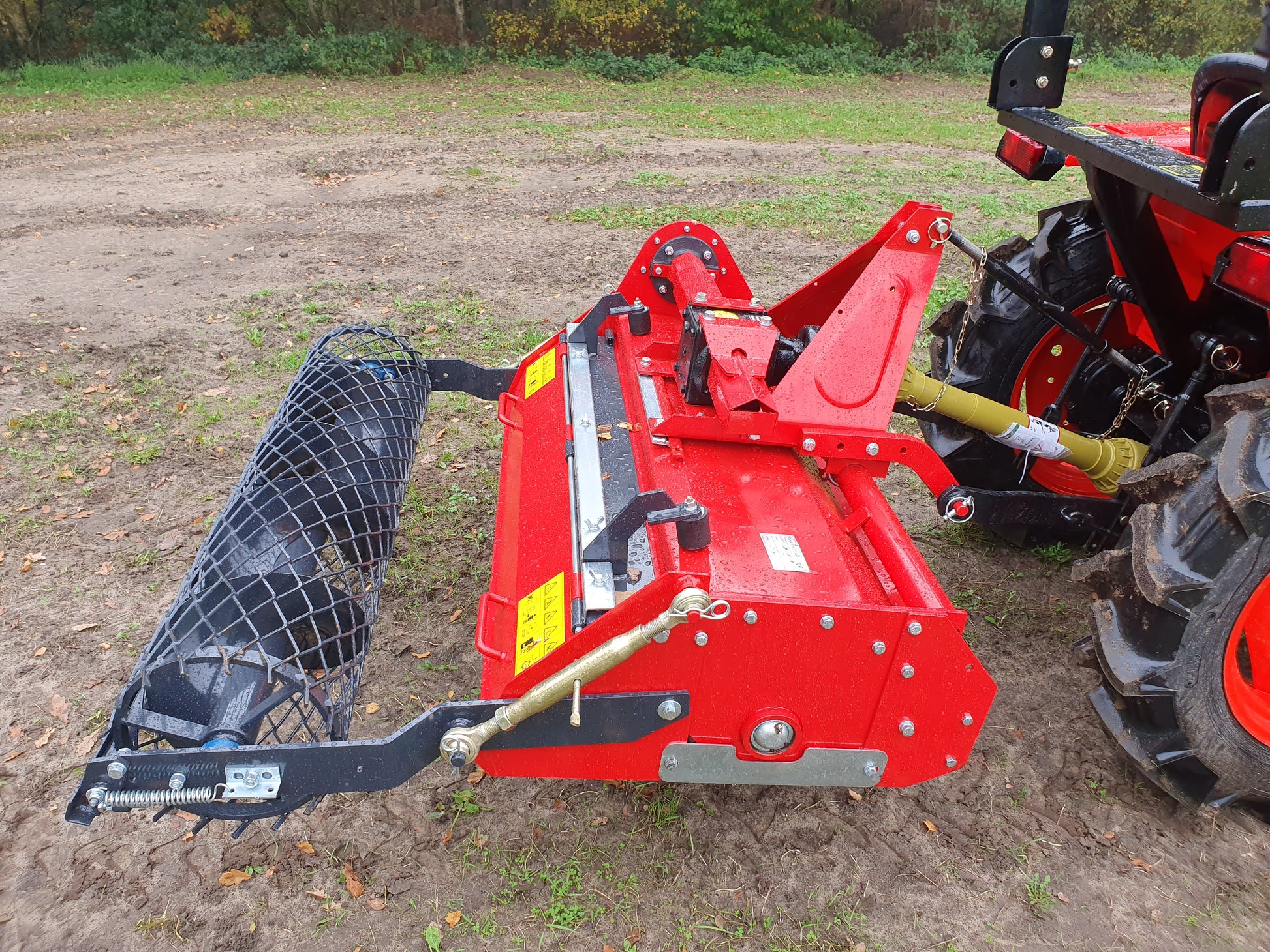 FarmMaster tractor stone burier attachment on a tractor in an outdoor setting