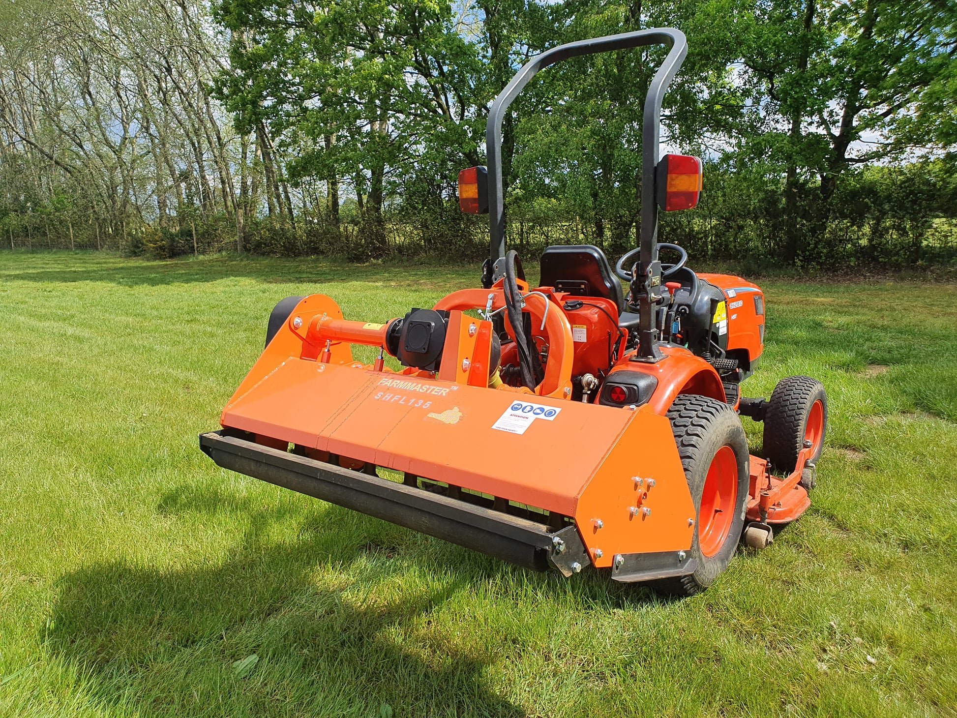 FarmMaster offset flail mower  on a grassy field with trees in the background