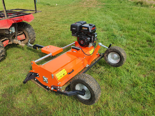 FarmMaster ATV flail mower attachment on a grassy field with a red ATV in the background.