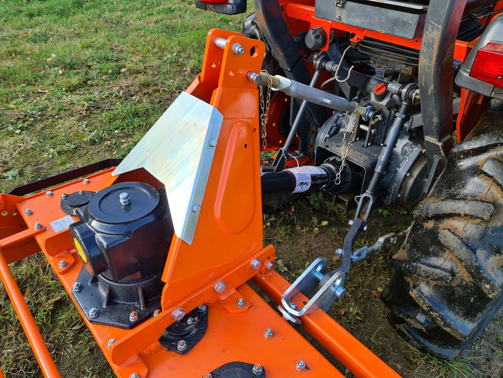 Close-up of a FarmMaster power harrow attachment on a grassy field