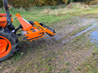 Tractor with a FarmMaster power harrow attachment on a muddy field