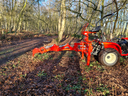 Red tractor with a FarmMaster LandLugger tractor backhoe in a forest clearing