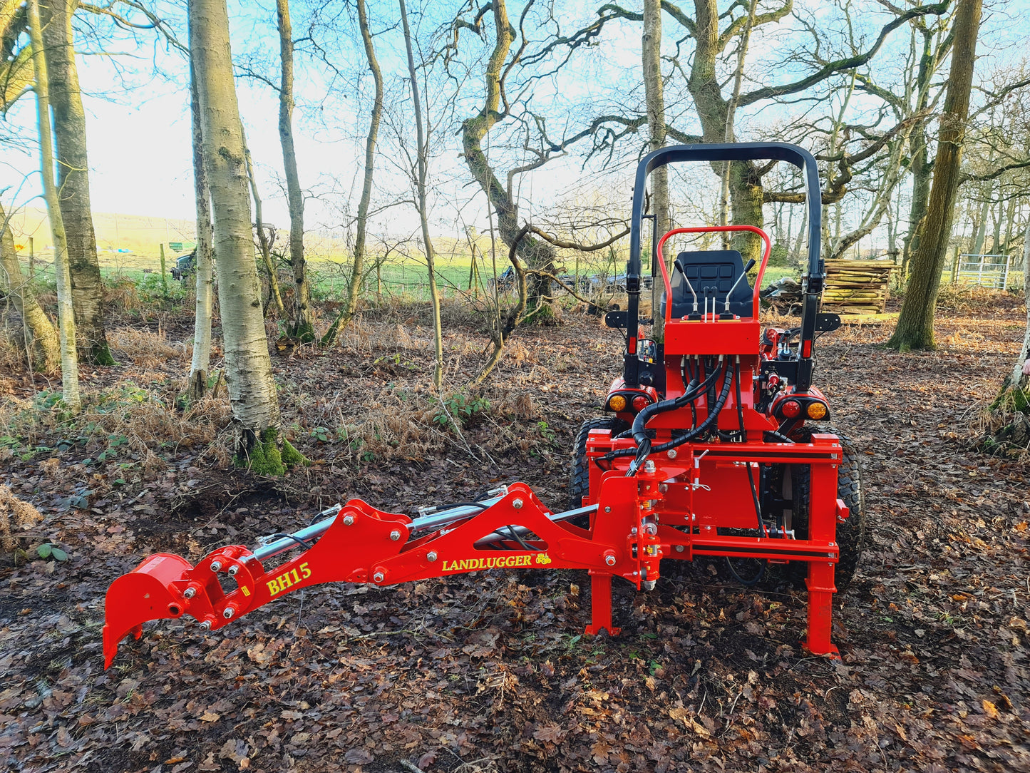 FarmMaster LandLugger tractor backhoe in a forest setting