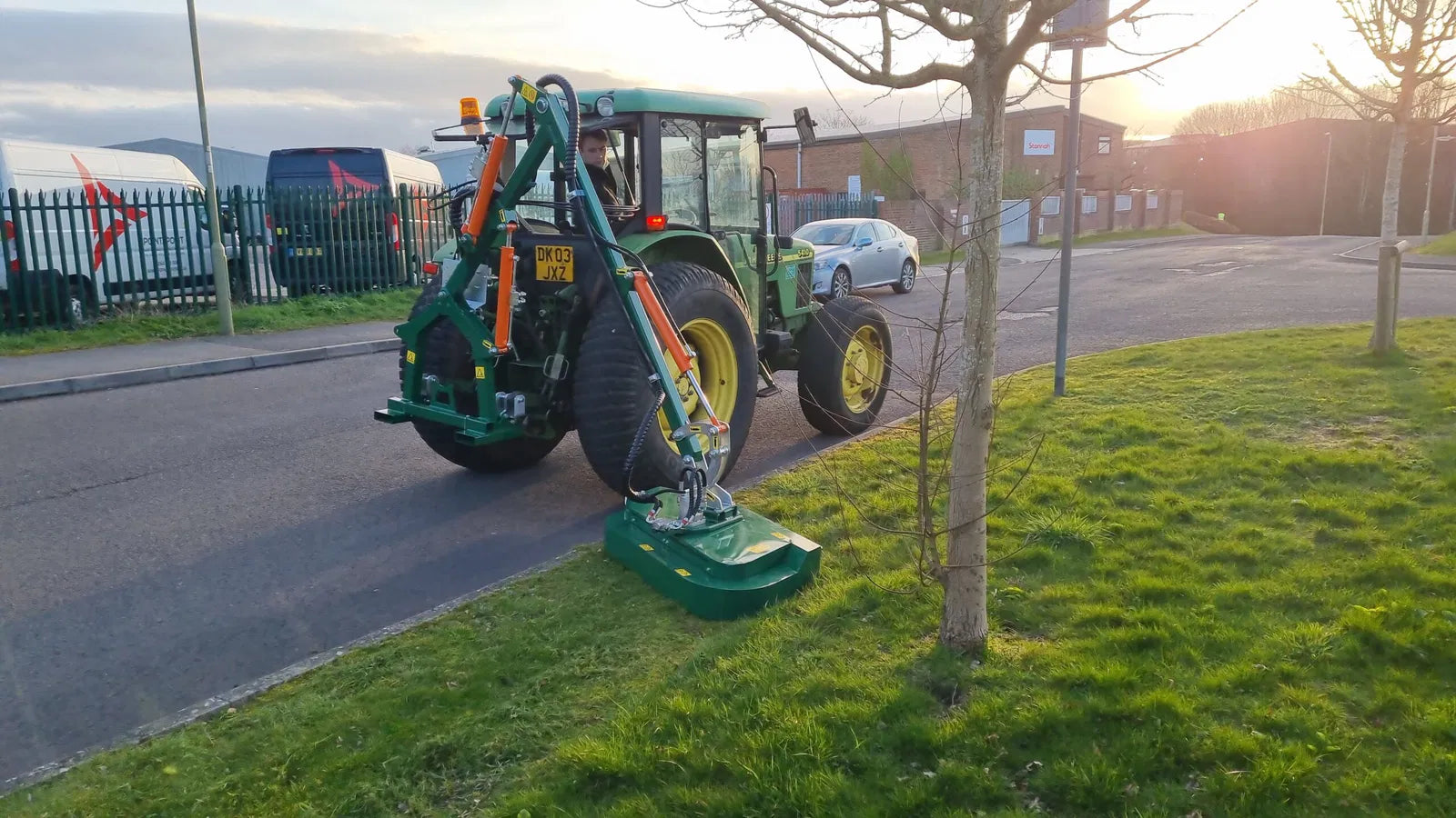 Tractor with a Wessex hedge cutter on a grassy area near a road