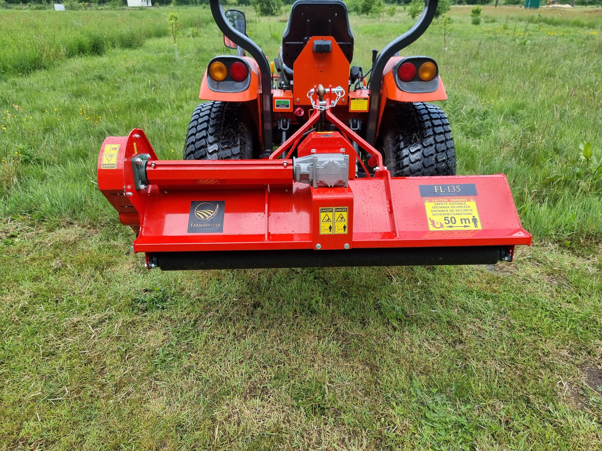 FarmMaster tractor flail mower attached to a tractor on a grassy field