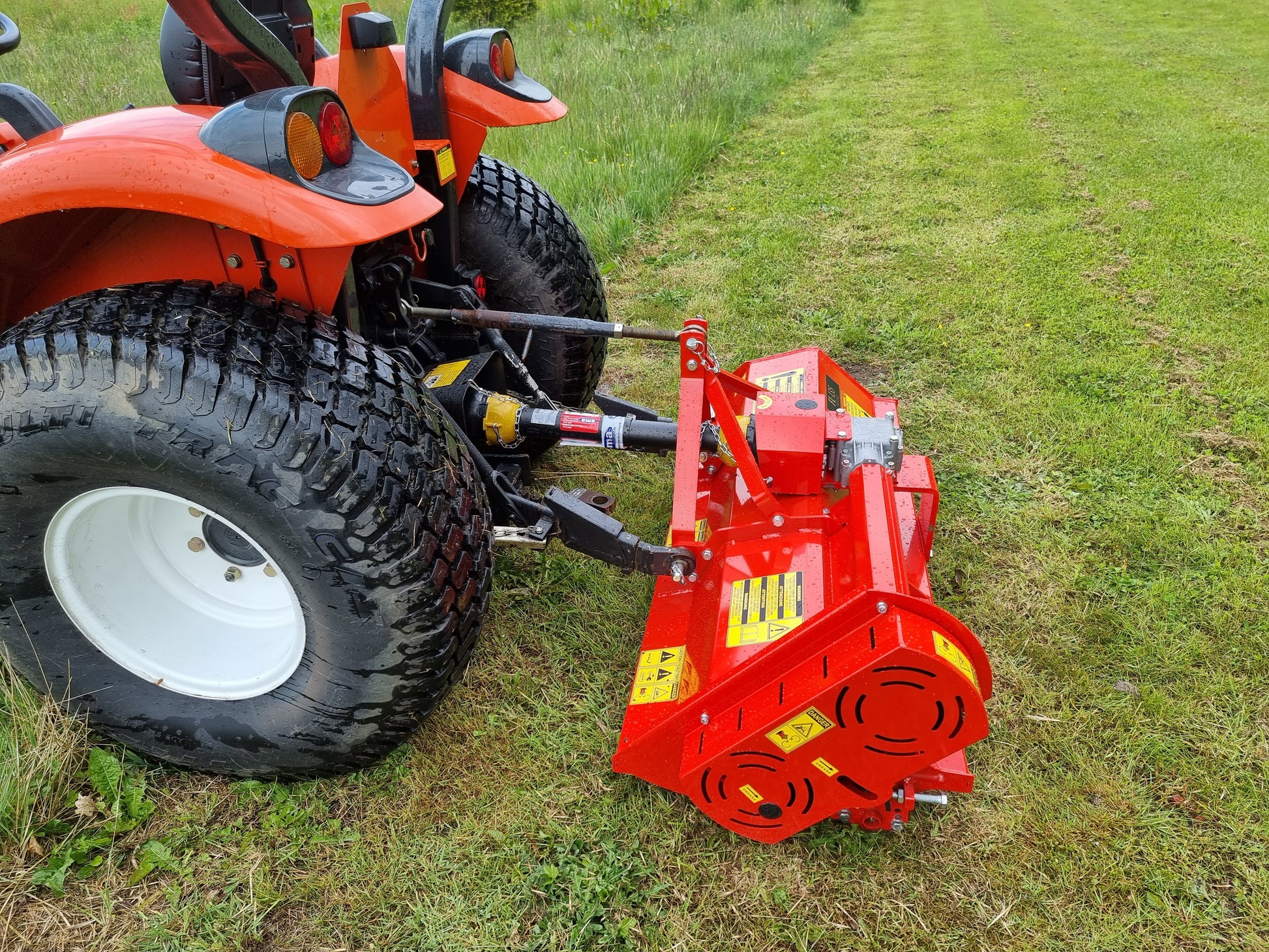FarmMaster Pro flail mower attachment on a lawn tractor in a grassy field