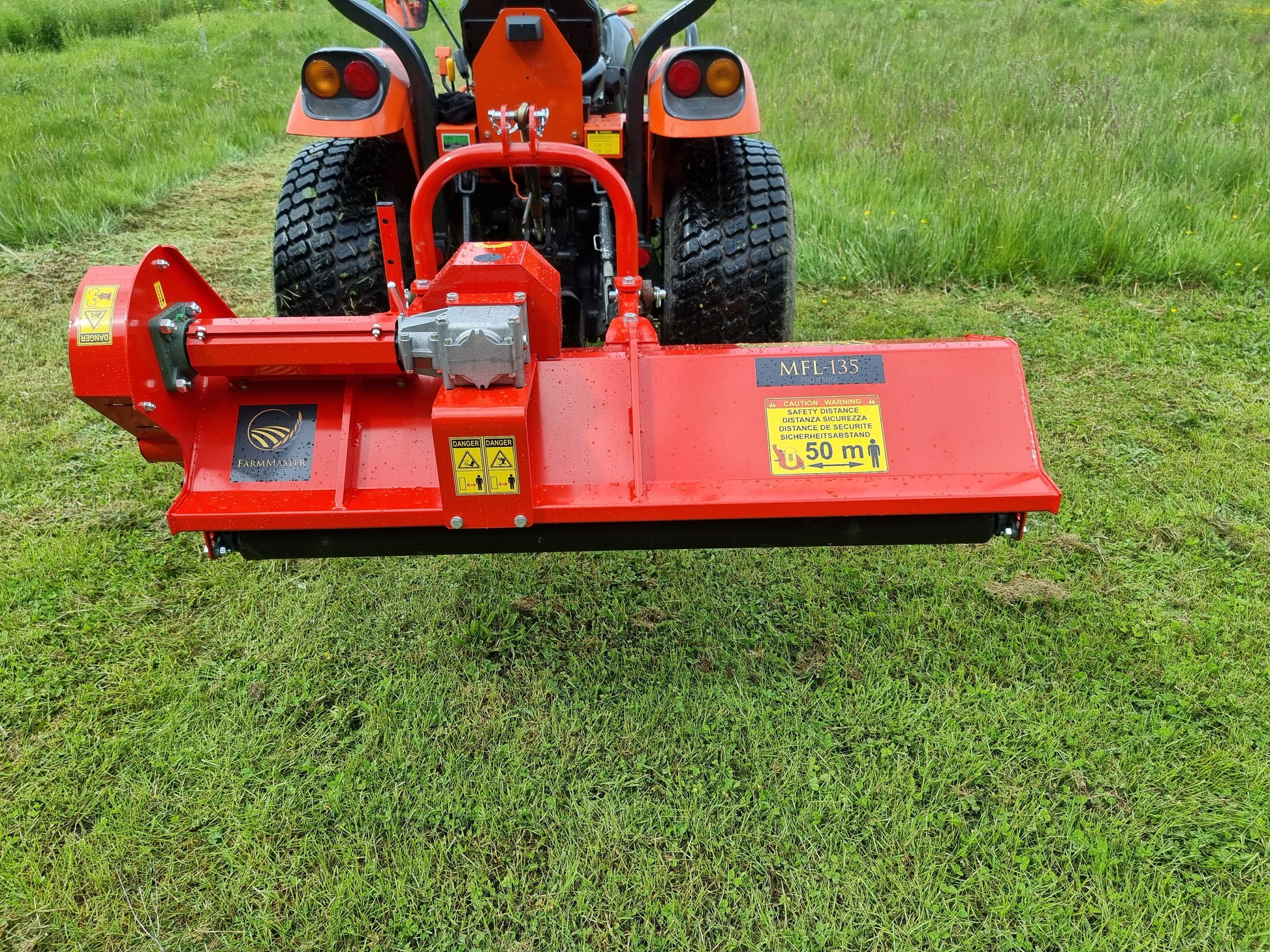 FarmMaster Pro offset flail mower  attached to a tractor on a grassy field