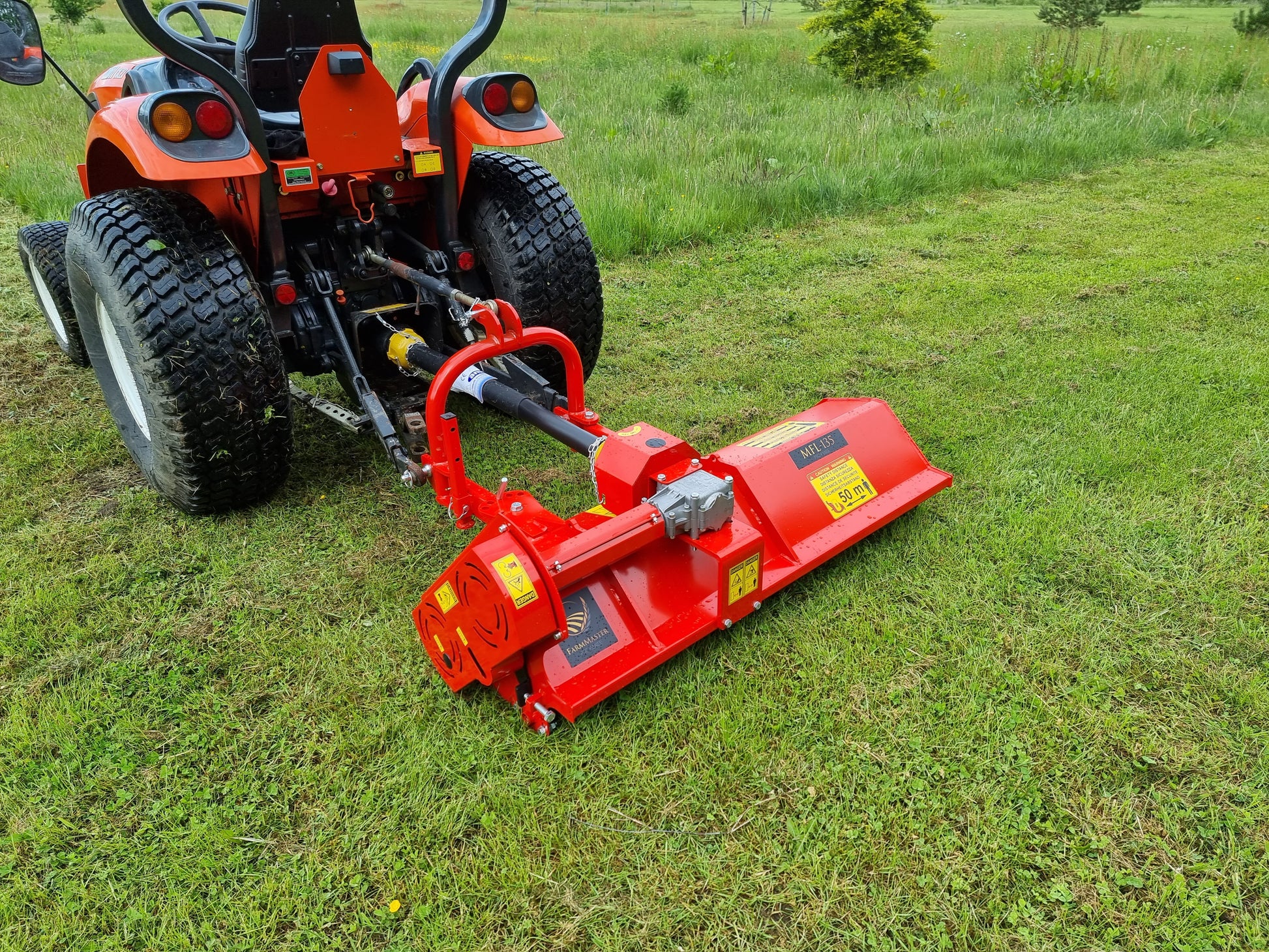FarmMaster Pro Side-Shift flail mower  attachment on a tractor in a grassy field