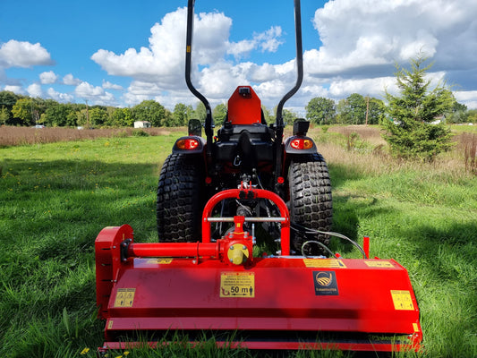 FarmMaster Pro flail mower in a field under a blue sky with clouds.