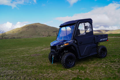 CFMOTO U600 UTV parked on grass with hills and blue sky in the background