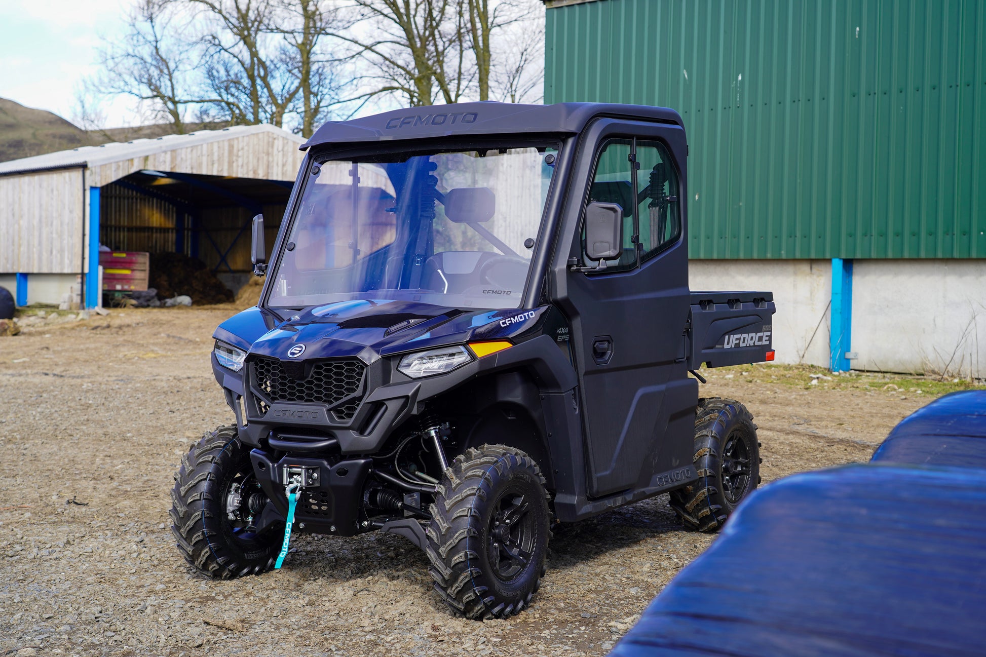 CFMOTO UTV parked in a rural setting with a building in the background