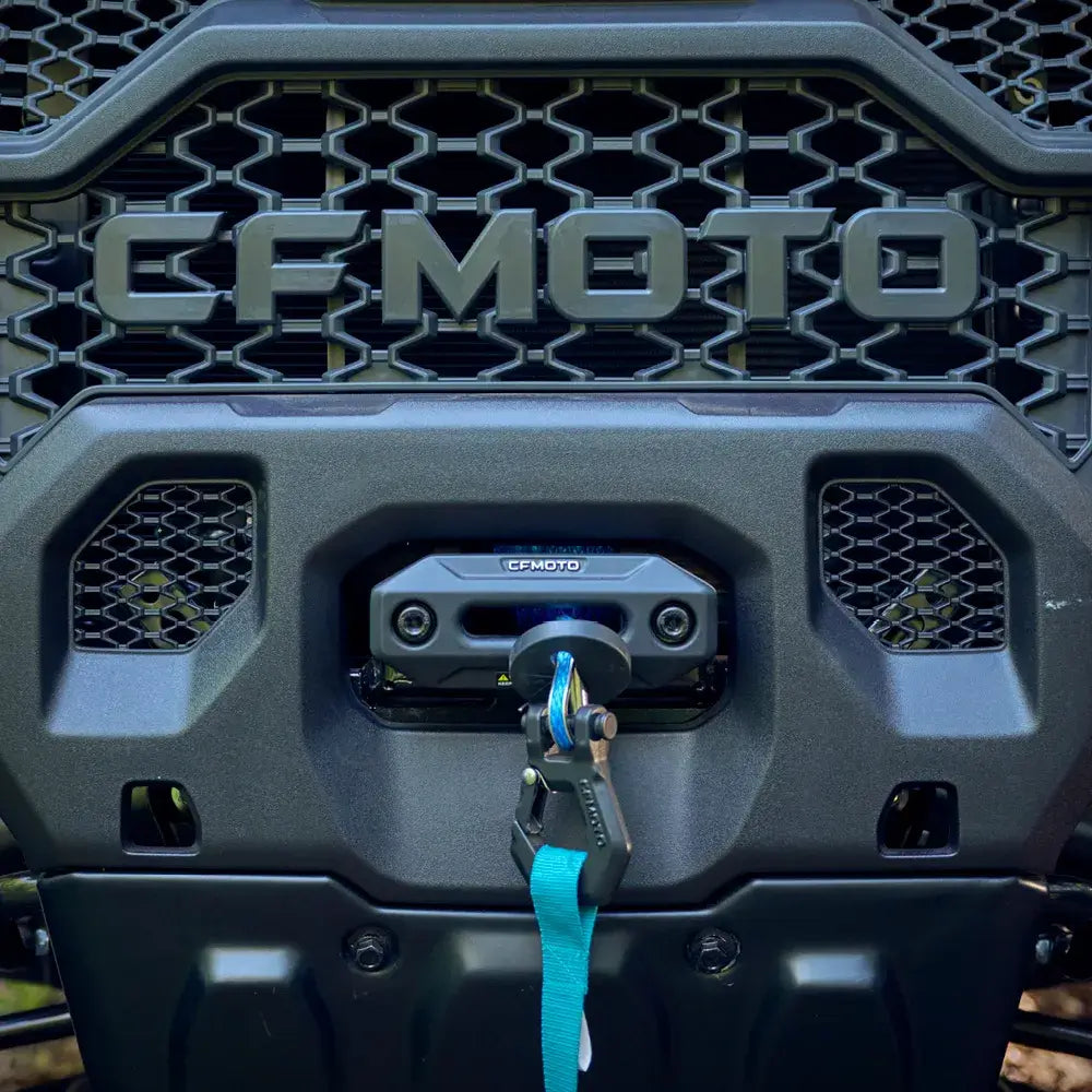 CFMOTO logo on a vehicle with a blue winch strap attached.