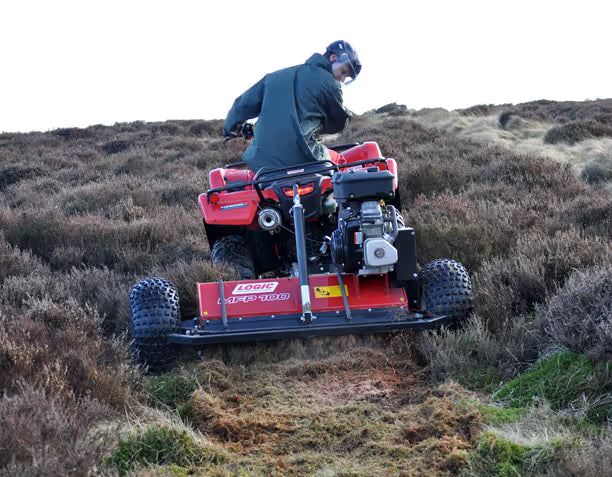 Person operating a Logic ATV flail mower on a grassy hillside.