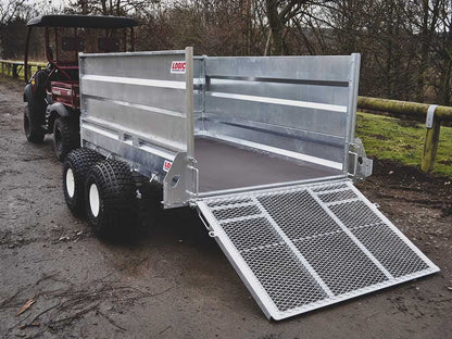 Metal trailer with open ramp on a dirt road, surrounded by trees and grass.