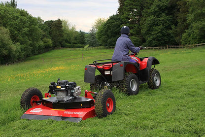 Person operating a Logic ATV topper mower on a grassy field.