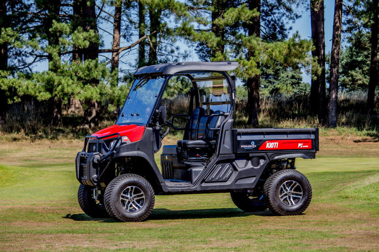 Kioti K9 Utility vehicle on a grassy area with trees in the background