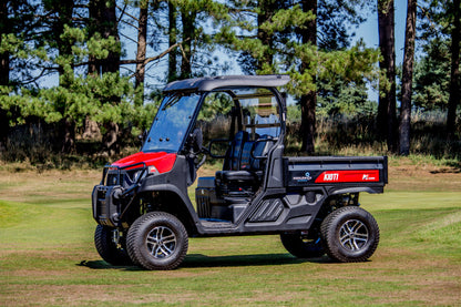 Kioti K9 Utility vehicle on a grassy area with trees in the background