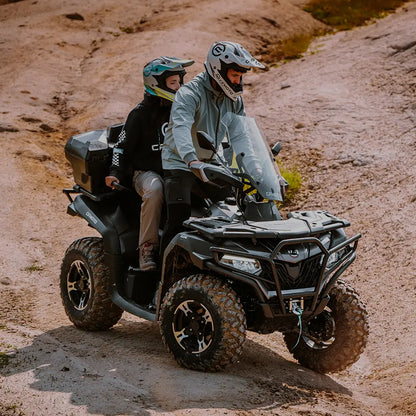 Two people on a CFMOTO ATV in a desert-like terrain
