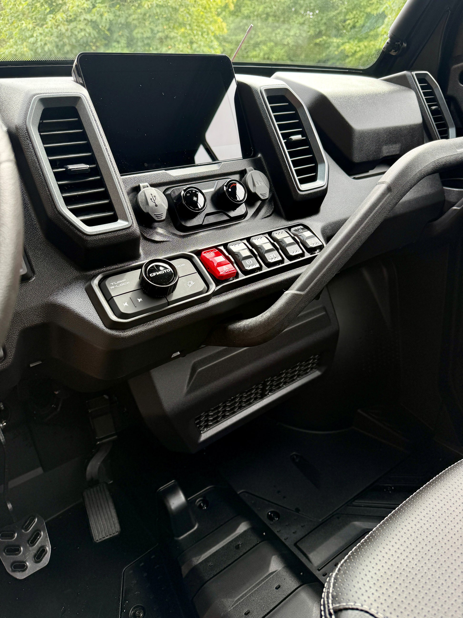 Close-up of a CFMOTO U10 Pro dashboard with controls and displays.