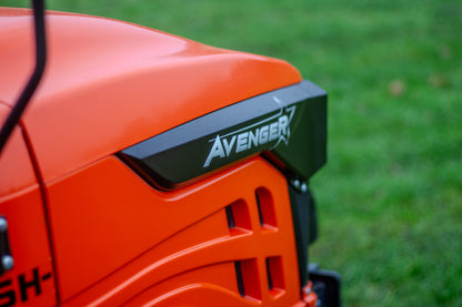 Close-up of an orange compact tract with 'Avenger' branding on a grassy background
