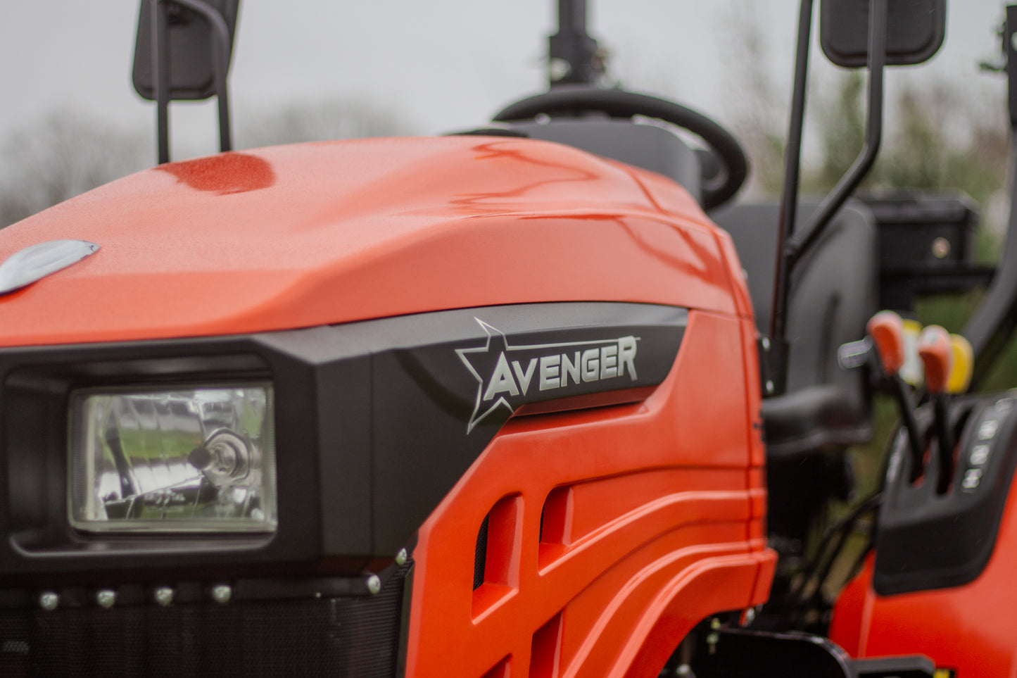 Close-up of an orange Avenger compact tractor with visible branding.