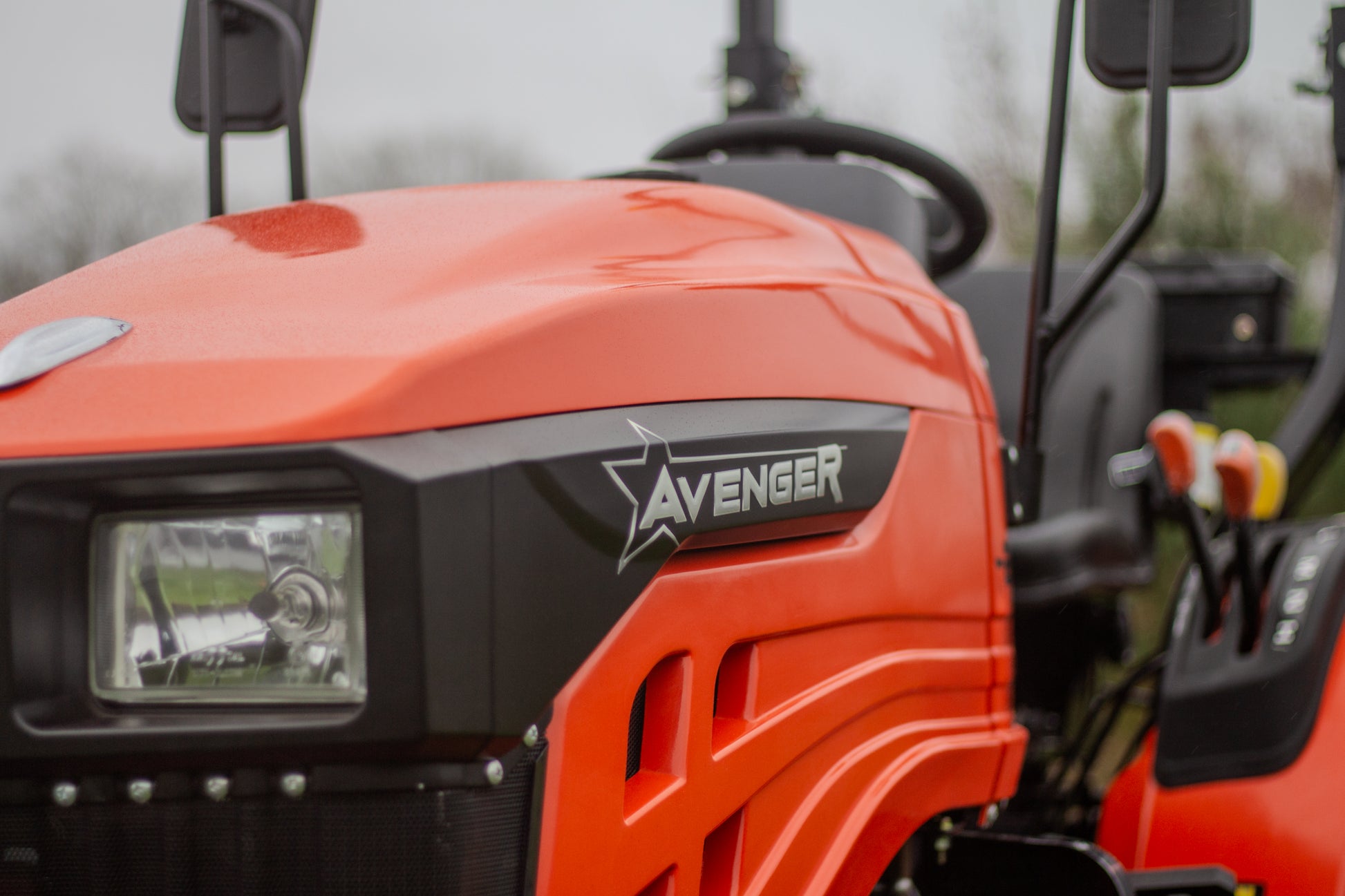 Close-up of an orange Avenger compact tractor with visible branding.