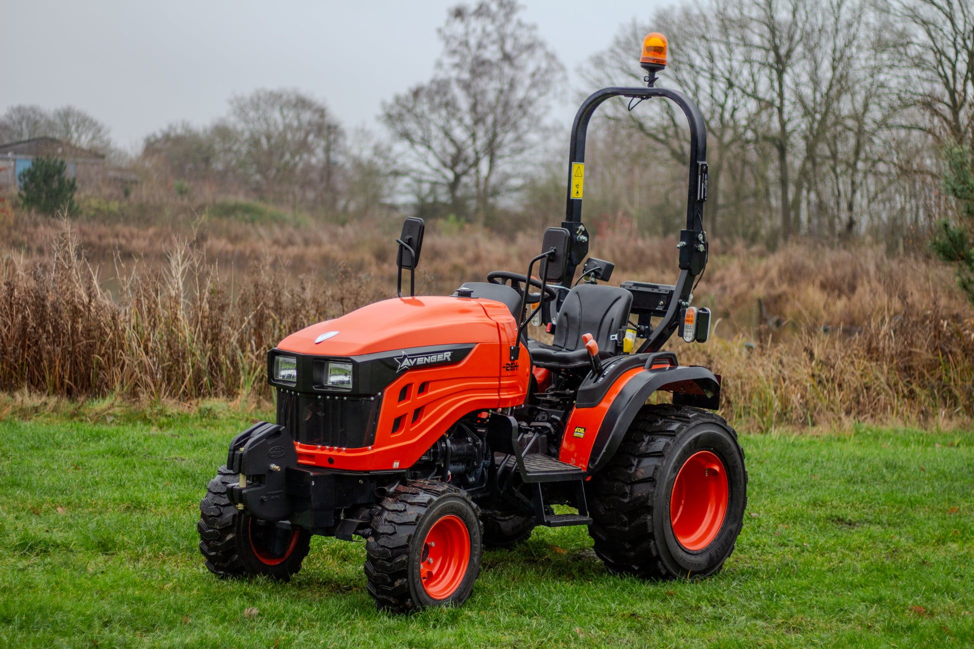 Avenger 26 tractor on a grassy field with trees in the background