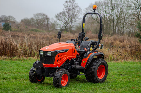 Avenger 26 tractor on a grassy field with trees in the background