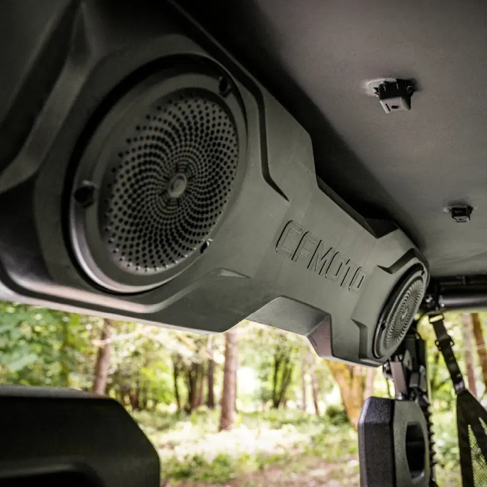 CFMOTO stereo system mounted inside a UTV vehicle with a forest background