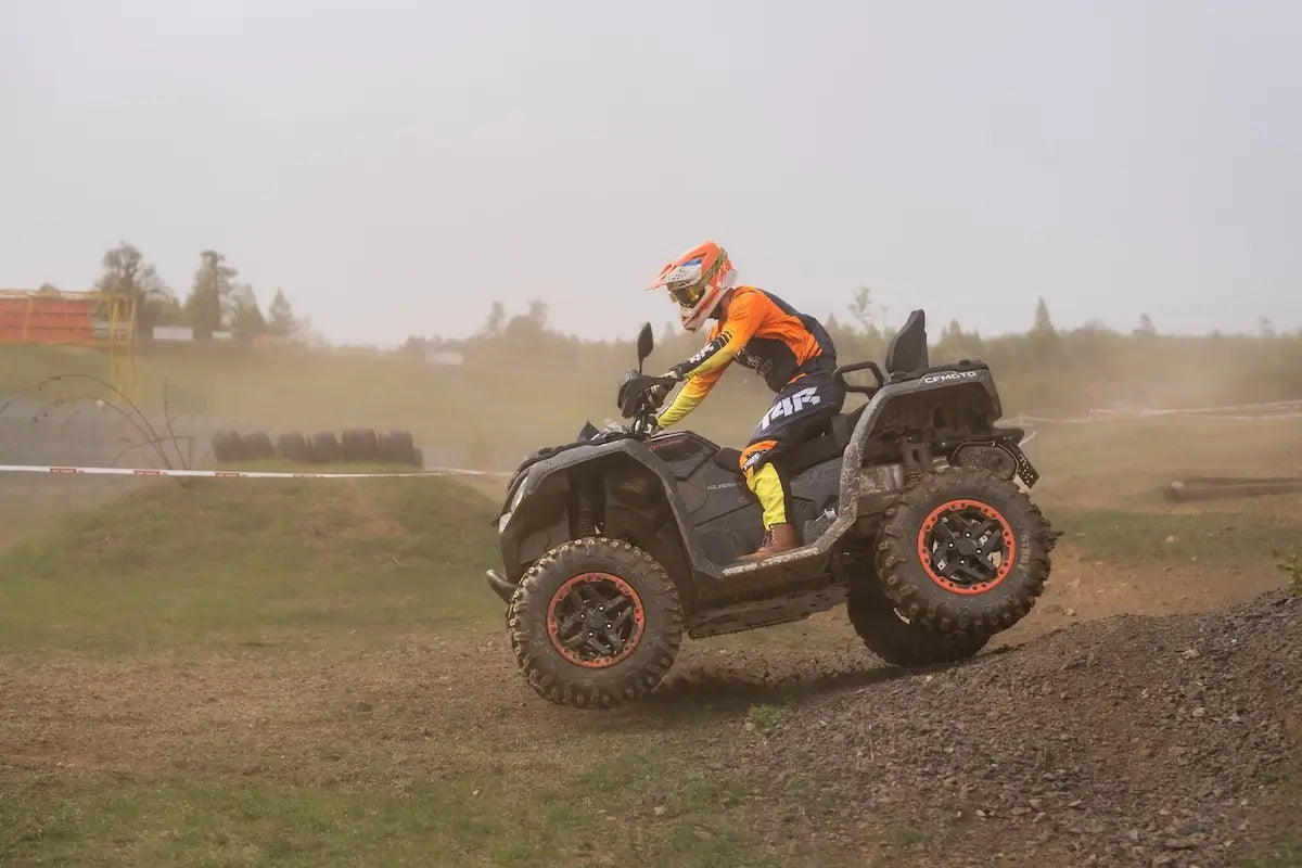 Person riding a CFMOTO ATV on a dirt track