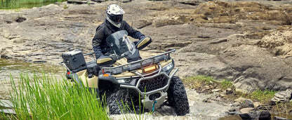 Person riding a CFMOTO ATV on rocky terrain