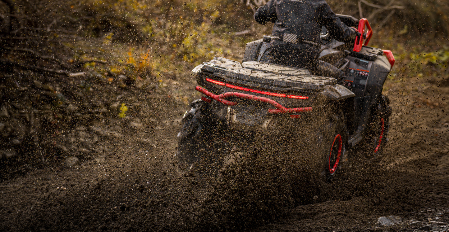Person riding a CFMOTO 1000 MV ATV through a muddy landscape