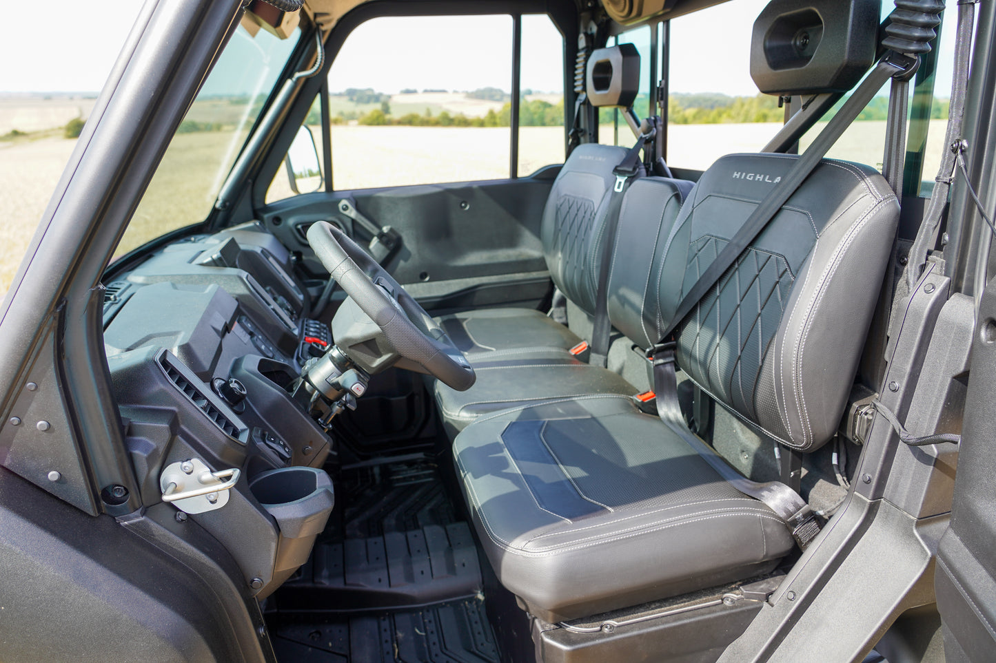 Interior of a CFMOTO U10 Pro with steering wheel and seats, showing a clear view of the dashboard and windows.