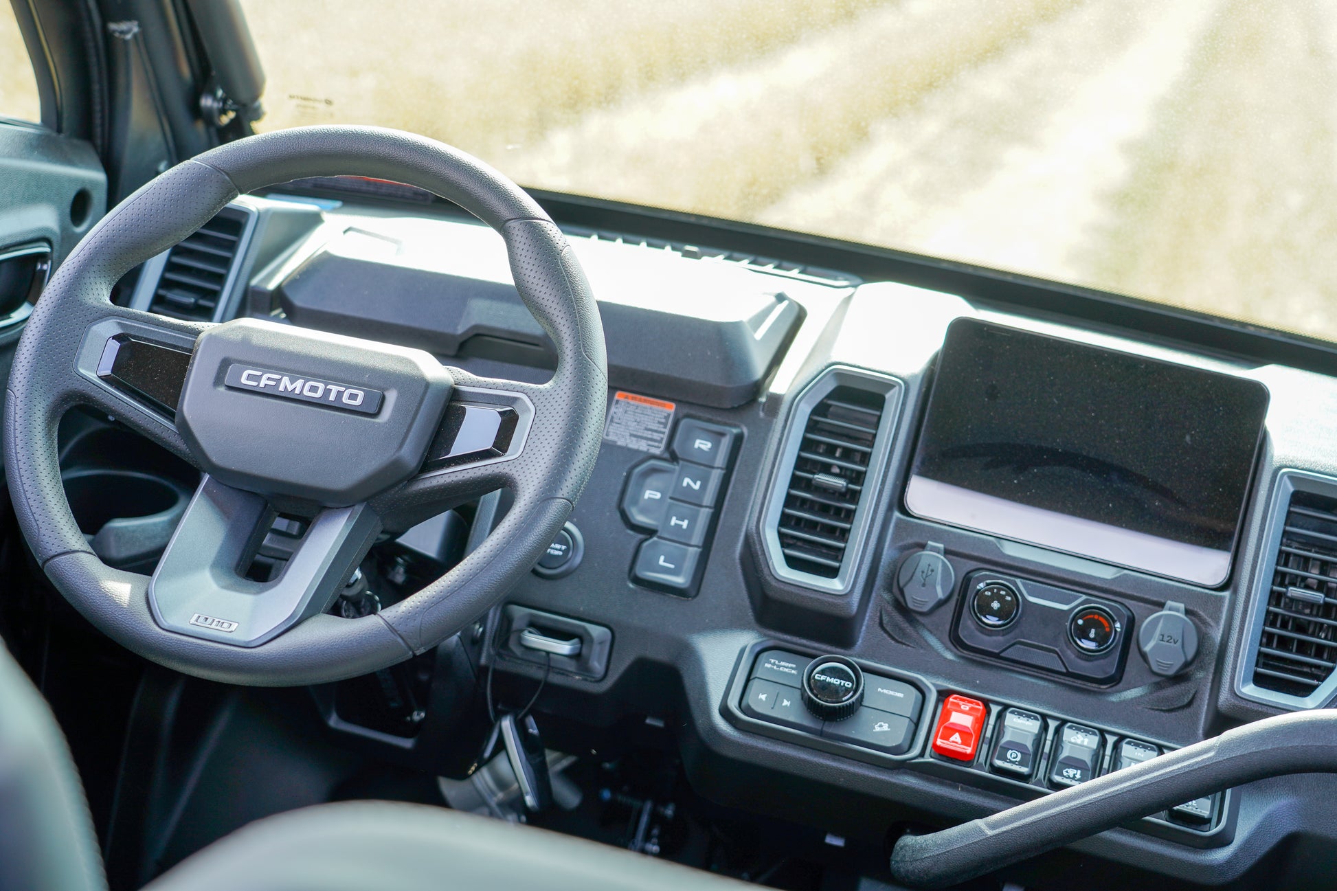 Steering wheel and dashboard of a vehicle with 'CFMOTO' branding.